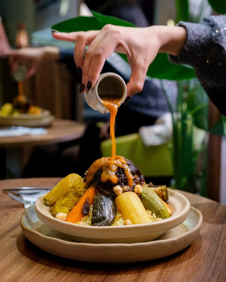 Sauce poured over couscous at La Kamounya